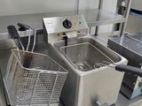 two deep fryers sitting on the counter in the kitchen