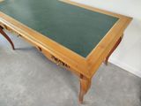 a table with a green top and a wooden base