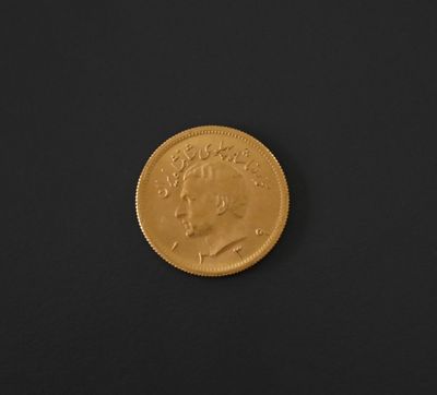 a close up of a gold coin on a black surface