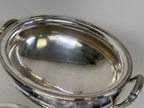 a silver plate with a spoon and spoon rest on a table