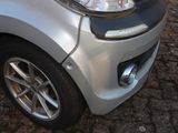 a small silver car parked on a cobblestone street