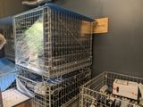 a man standing in front of a cage filled with bottles of wine