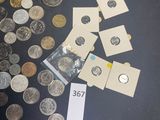 a pile of coins on a table next to a calculator