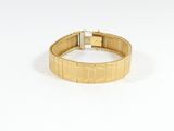 une image d'un gros plan d'un bracelet en or sur un fond blanc