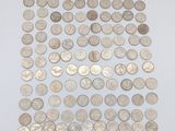 une pile de pièces d'argent posée sur une surface blanche