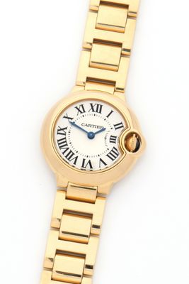 a close up of a gold wrist watch with roman numerals