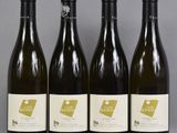 four bottles of wine are lined up on a table