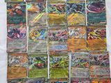 a pile of pokemon cards sitting on top of a white sheet