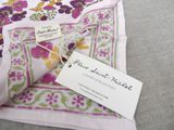 a pink and green floral scarf with a tag on it