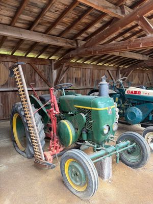 deux vieux tracteurs dans une grange, avec une échelle