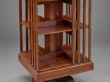 an antique wooden display case with three shelves on casteors