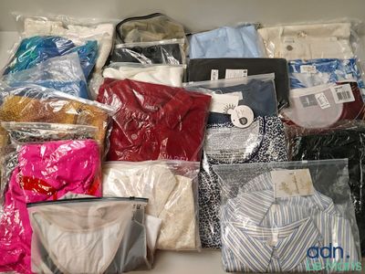 de nombreux types de chemises, rangées dans des sacs sur une étagère