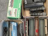 many different types of toy trains in boxes on the ground