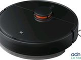 le robot est branché à un chargeur posé sur une surface blanche