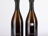 deux bouteilles de champagne posées l'une à côté de l'autre sur une surface blanche