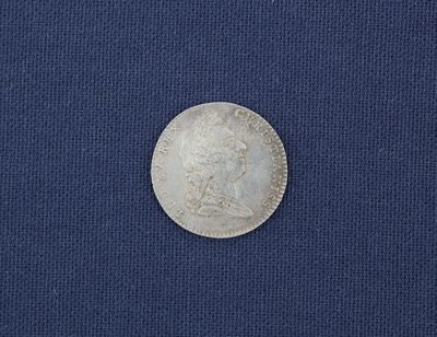 un gros plan d'une pièce de monnaie posée sur un tissu bleu