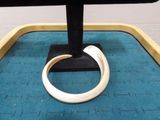 a white ring on a black stand on a blue mat