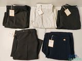 quatre pantalons pour homme sont alignés sur une surface blanche
