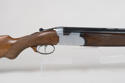 a close up of a rifle with a wooden barrel on a clear stand