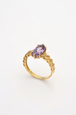 une bague en or sertie d'une pierre d'améthorate au centre