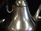 a silver tea pot sitting on top of a saucer