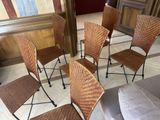 six wicker chairs are arranged in a circle on a tiled floor