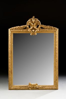 an ornately carved mirror with a gold frame on a white surface