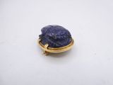 a close up of a gold ring with a blue stone in it