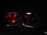 pair of red garnets on a black surface