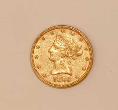 a close up of a gold coin with a woman ' s head on it