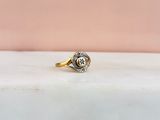 a close up of a gold and diamond ring on a marble surface