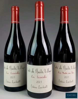 three bottles of red wine sitting on top of a table
