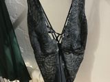 a black bra top hanging on a wall next to a radiator