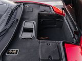 a red car with its trunk open and a phone in the trunk