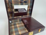 a brown suitcase with a checkered cloth inside of it