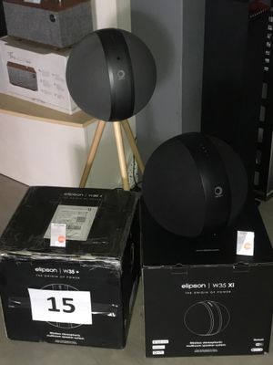 deux enceintes noires posées sur des cartons au sol
