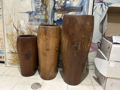 Trois grands vases en bois cylindriques.