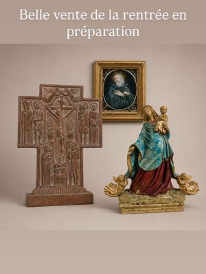 une statue représentant une femme tenant un bébé dans ses bras, à côté d'une croix