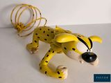a toy of a cheetah laying on a white surface