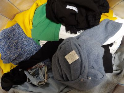 a pile of clothes sitting on the floor next to a chair