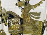 a picture of a gold and black scarf with a man on a horse
