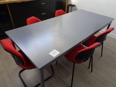une table noire avec des chaises rouges et un meuble noir