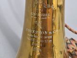 a brass bell sitting on a table next to a basket of flowers