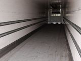 an image of a long narrow tunnel with a clock on the wall