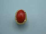 a close up of a ring with a red stone in it