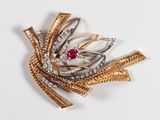 une image représentant une broche en or et diamants ornée d'une pierre rouge