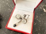 a silver brooch in a red box on a table