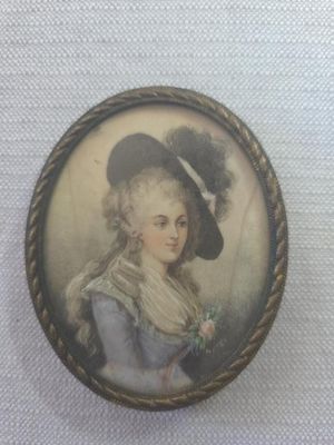 an old picture of a woman wearing a hat and holding a flower