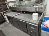 une photo d'une cuisine professionnelle équipée d'appareils électroménagers et de plans de travail en acier inoxydable