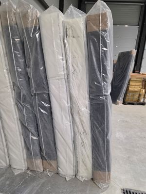 de nombreux rouleaux de matelas emballés dans du plastique dans un entrepôt